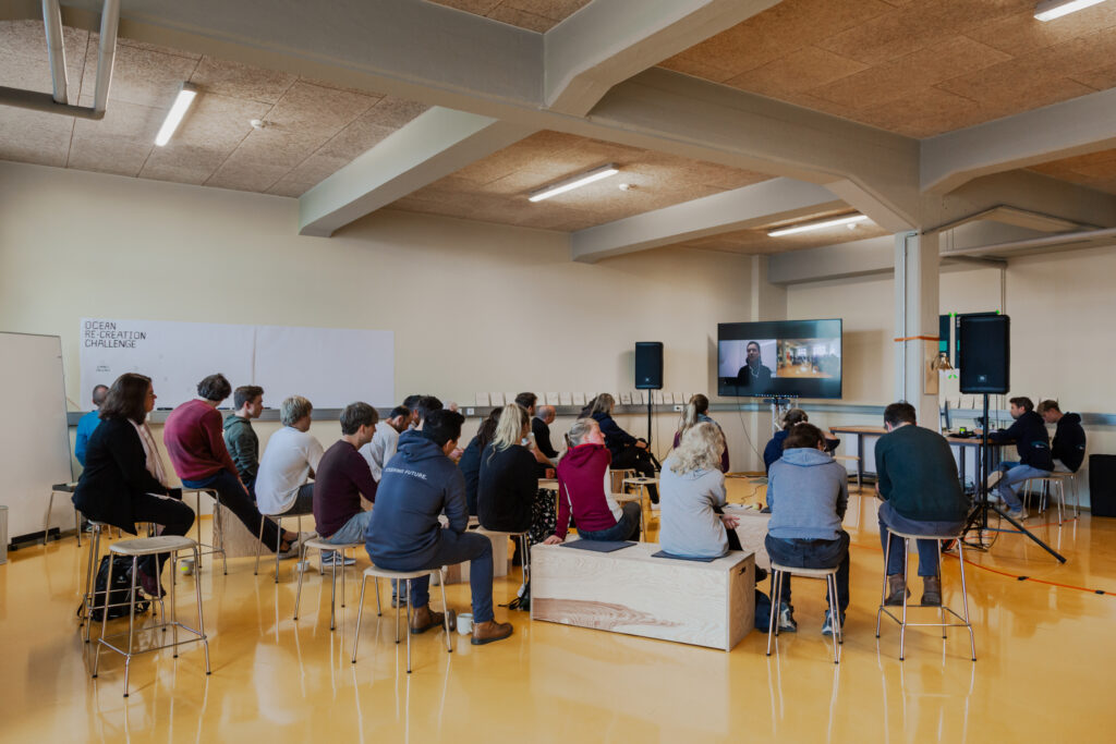 Workshopteilnehmer*innen der ORCC 2022 hören einem hybriden Vortrag vor Ort im LAB im TMT zu