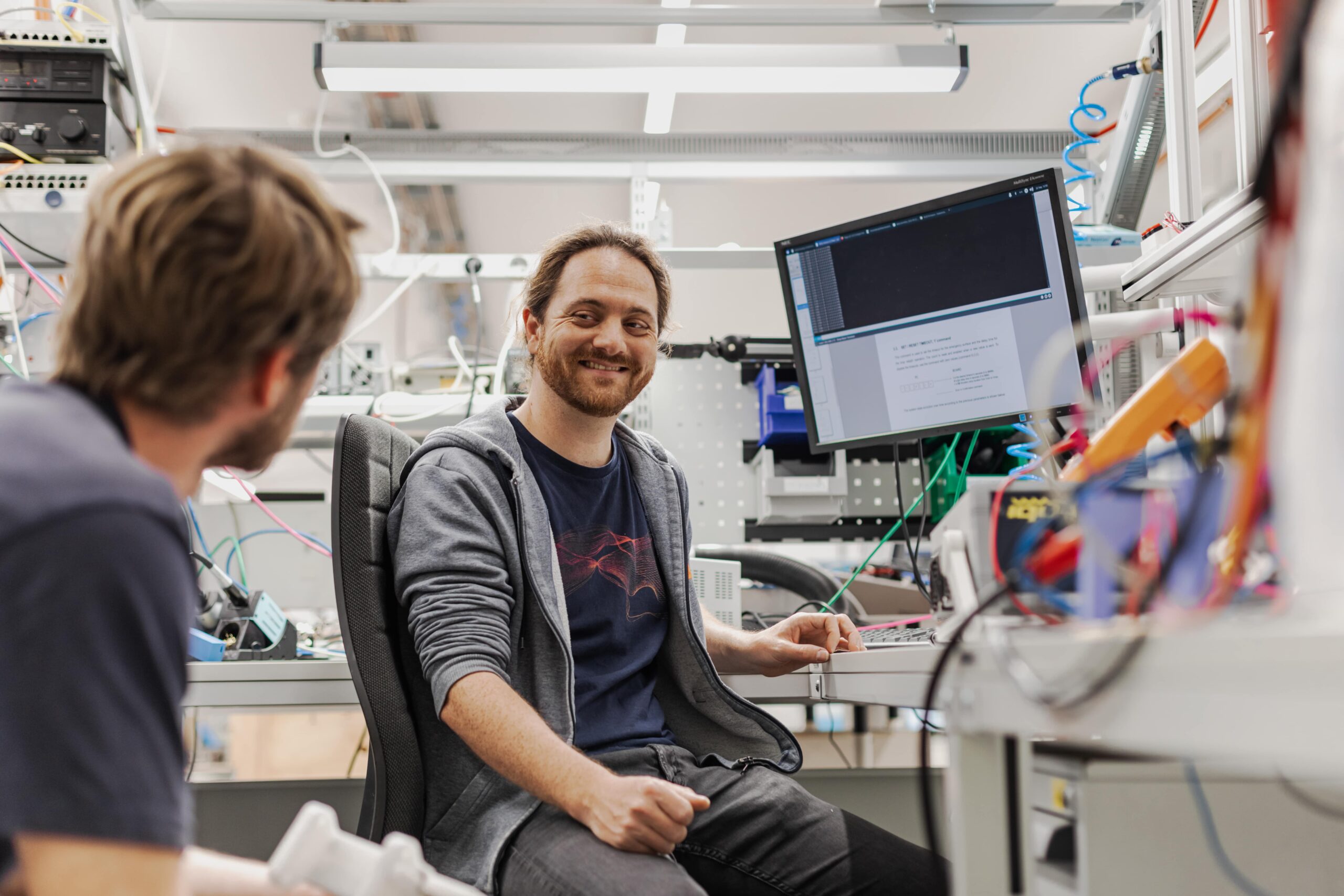 Zwei Wissenschaftler sind im Labor umgeben von technischen Geräten